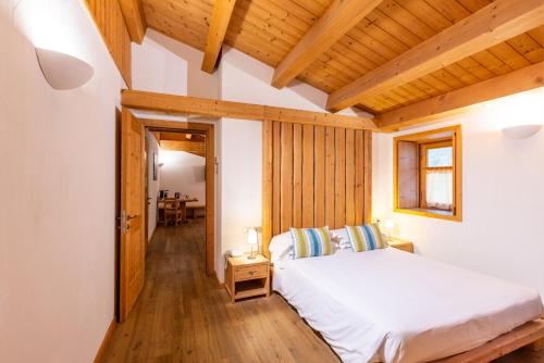 a bedroom with a white bed and a wooden ceiling at Agriturismo La Fiorida in Mantello