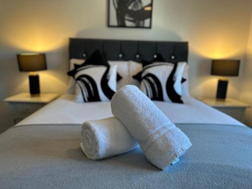 a pair of towels sitting on top of a bed at Dovefield House - Modern 3 Bed Home from Home - Alton Towers, Uttoxeter Races in Uttoxeter