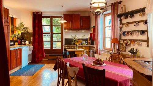 une cuisine et une salle à manger avec une table et des chaises dans l'établissement La maison des vignes, à Katzenthal