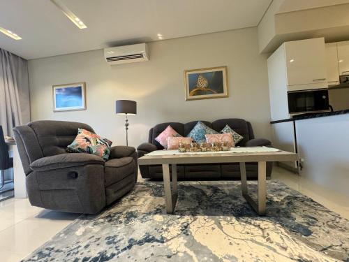 ein Wohnzimmer mit einer Couch und einem Couchtisch in der Unterkunft Mimosa in Salalah