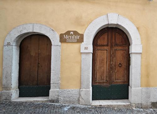 two wooden doors on the side of a building at Menhir Rooms in Campobasso