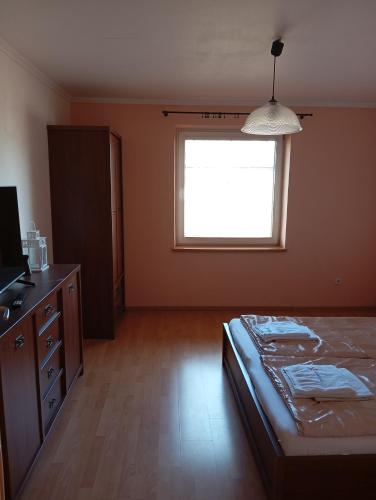 a bedroom with a bed and a dresser and a window at Relax Vila se zahradním wellness in Ostrava