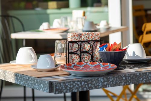 une table avec des assiettes et des bols sur une table dans l'établissement Suite Fontanella, à Porto SantʼElpidio