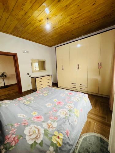 a bedroom with a large bed with flowers on it at Bert-House close to the sea in Lezhë
