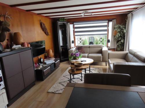 a living room with a couch and a table at Veluwe Park Reewold Chalet Vision in Putten