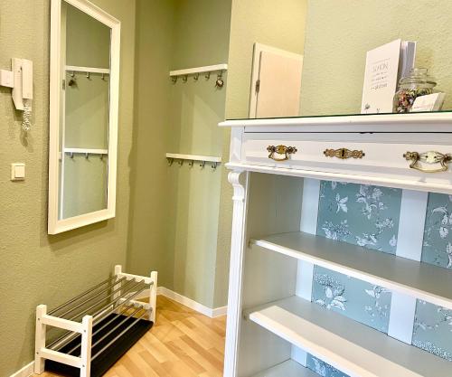 une salle de bains avec des murs verts et une étagère blanche dans l'établissement Appartement "STADTGEFLÜSTER" im Zentrum, inkl Stellplatz, 2 Betten, Babybett, Balkon, gratis Kaffee und Tee, WLAN, à Bautzen