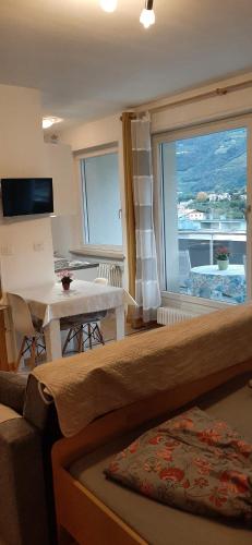 a room with a large window with a table and a view at Merano Panoramablick ruhig gelegen in Merano