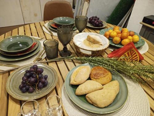 a wooden table topped with plates of bread and fruit at Casa do Adro in Corte do Gafo de Cima