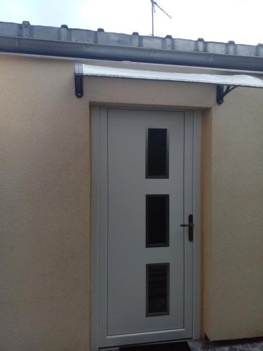 a garage with a white door on a house at Charmant Studio indépendant in Louvres