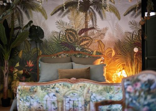 a bedroom with a bed with a tropical wallpaper at Manoir la grande guerais in Beaussais sur Mer