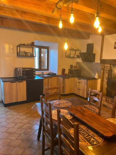 a kitchen and dining room with a wooden table at Gîte Charmant La Combette in Thouron