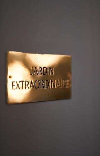 a gold sign that reads jardinian antiquatio dstg at Manoir la grande guerais in Beaussais sur Mer