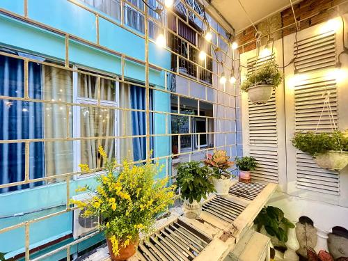 a balcony with potted plants on a blue building at Sora Home - 3 mins to Hoan Kiem Lake in Hanoi