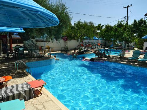a large swimming pool with people laying in it at Kastro Studios Apartments in Myrtos