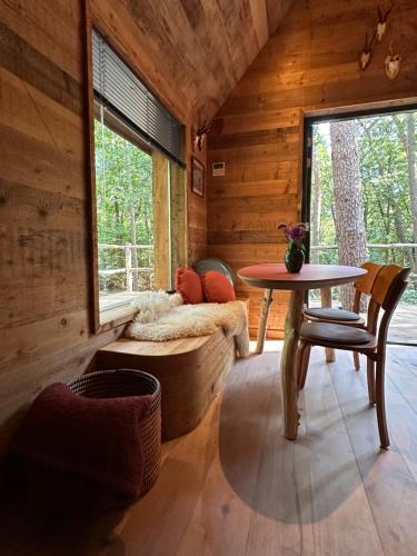 a room with a bed and a table in a cabin at New Unique Treehouses with hot tub in Oisterwijk in Oisterwijk
