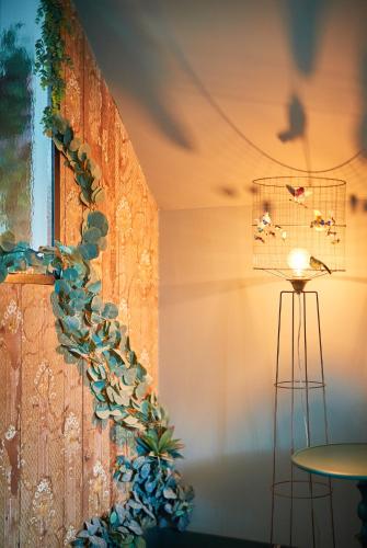 a room with a plant on the wall and a lamp at Manoir la grande guerais in Beaussais sur Mer