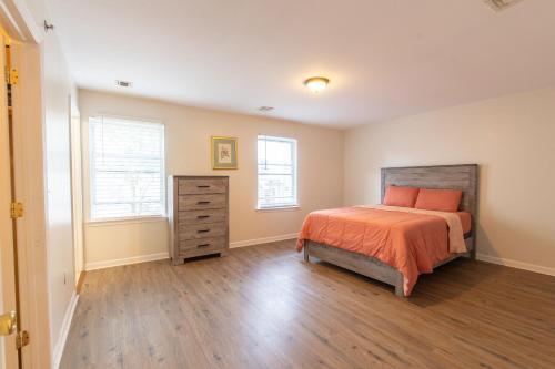 a bedroom with a bed and a dresser and two windows at 4 Bedroom-Airport Convient in University of Medicine and Dentistry Rooftop Heliport