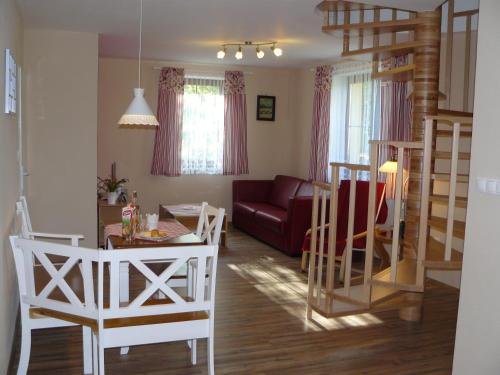 Una sala de estar con una mesa y sillas y un sofá. en Privát Za Lesíkom, en Ždiar