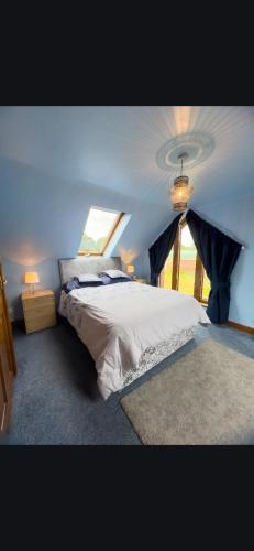 a bedroom with a large bed and a window at Tarnside Cottages in Brampton