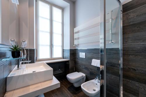 a bathroom with a sink and a toilet and a window at Corte Novella Hotel & Residence in Brescia