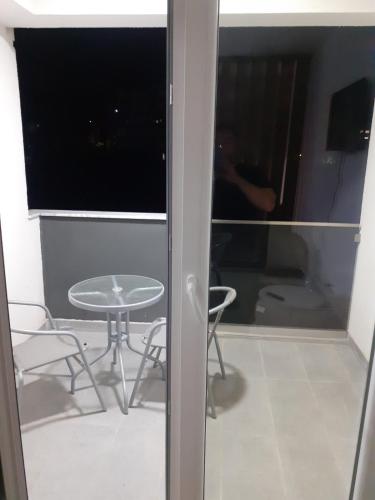 a table and chairs in a room with a window at Twins Apartment in Strumica