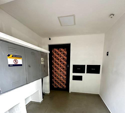 a room with a door with a bunch of wine bottles at Quarto individual Vila Olimpia in Sao Paulo