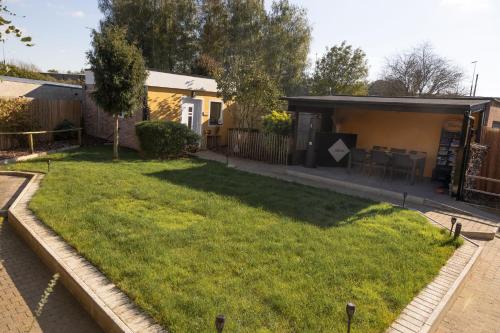 a house with a large lawn in front of it at Alivio - Thuiskomen bij jezelf op vakantie in Lummen