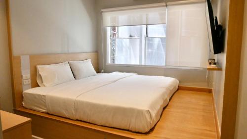 a bedroom with a white bed and a window at The Staytion Hotel at Sukhumvit in Amphoe Phra Khanong