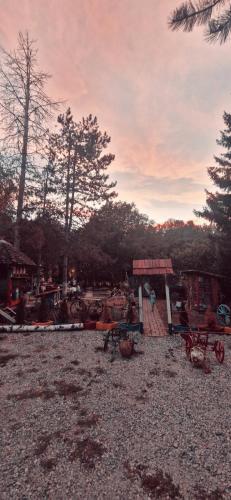 un parque con mesas de picnic y un edificio con árboles en Etno selo Dukat, en Belo Polje