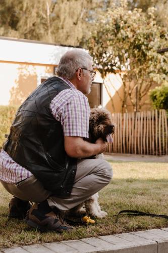a man squatting down with a dog in a backpack at Alivio - Thuiskomen bij jezelf op vakantie in Lummen