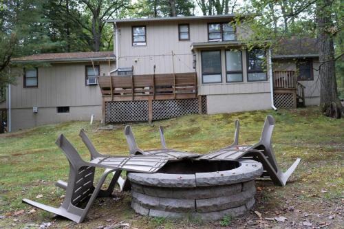 a fire pit in the yard in front of a house at Racc00ns Retreat in Lake Harmony