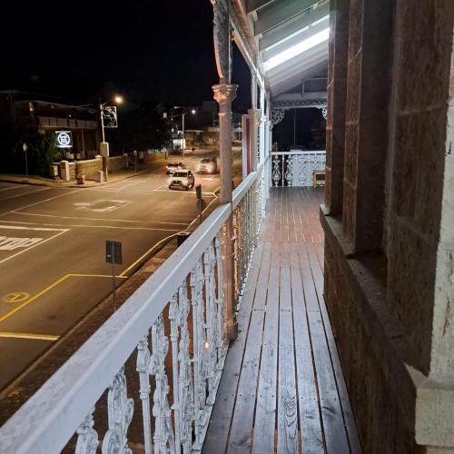 a balcony of a building with a street at night at Green Door Guesthouse in Mossel Bay