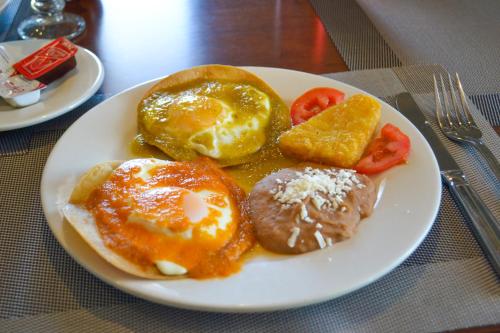 a plate of breakfast food with eggs and potatoes and tomatoes at Hotel Aeropuerto Los Cabos in San José del Cabo