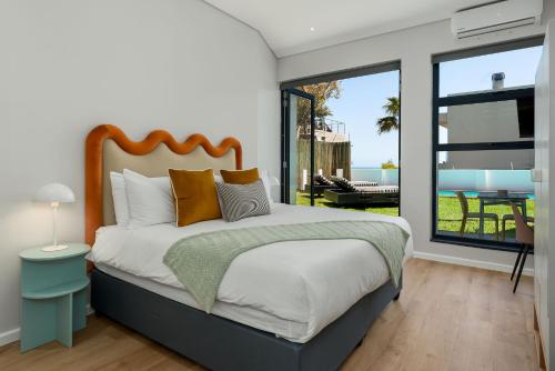 a bedroom with a large bed and a balcony at Neighbourgood 1st Crescent in Cape Town