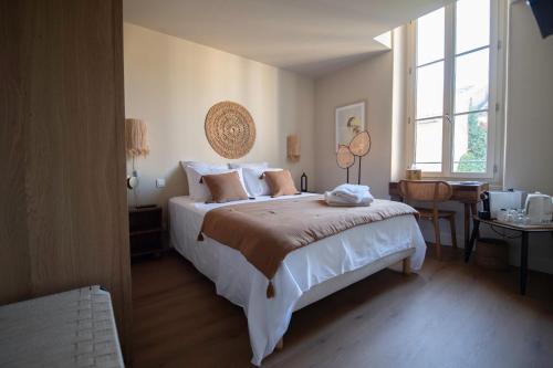 a bedroom with a large white bed and a window at La Maison Clémenceau in Salon-de-Provence