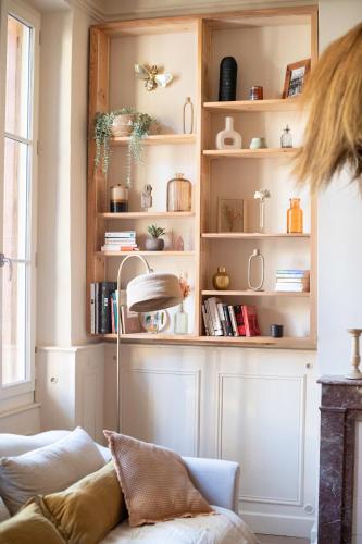 a living room with a couch and shelves with books at La Maison Clémenceau in Salon-de-Provence