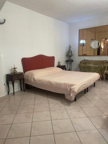 a bed in a room with a tiled floor at Maison Angelo - citra 8055LT2291 in Sanremo