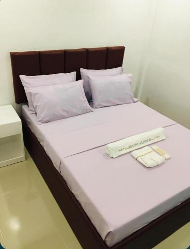 a bed with a book and a thermometer on it at Mommy Mia Bed and Breakfast in Dasag