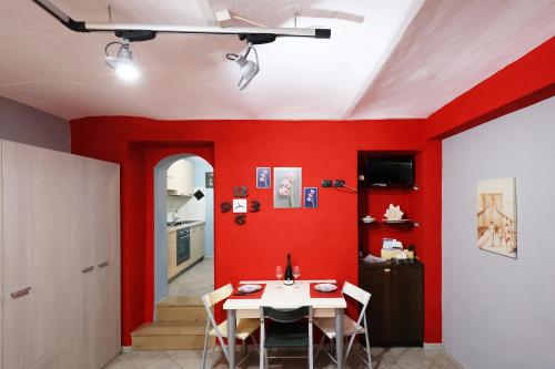 a dining room with red walls and a table at Casa vacanze Re Cit Diano d'Alba in Diano dʼAlba