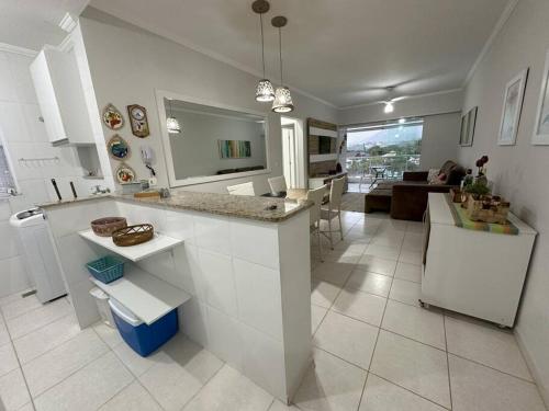 Una cocina con encimera y una sala de estar. en Apartamento lindo na praia da enseada - Ubatuba, en Ubatuba