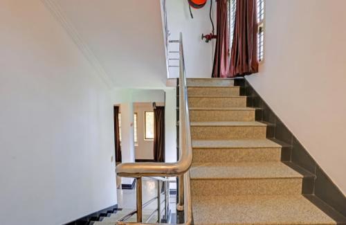 a stair case with a chair in a house at Luxe Lefort in Thiruvananthapuram International Airport