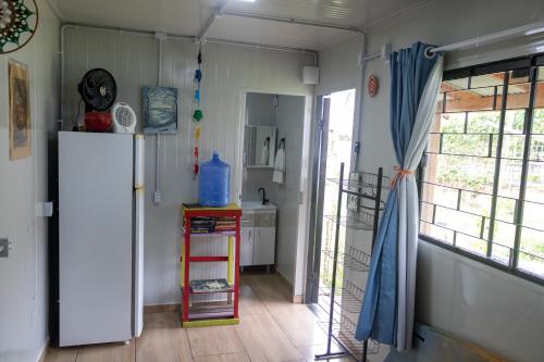 una cucina con frigorifero e tavolo con orologio di Suíte Sol & Lua a Penha