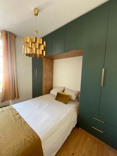 a bedroom with a large bed with a green cabinet at Demeure de charme in Lons-le-Saunier