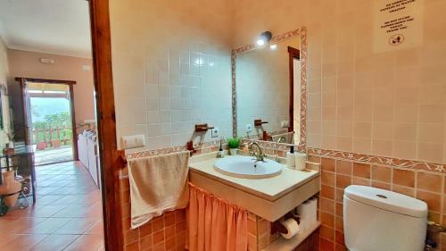 ein Badezimmer mit Waschbecken, Toilette und Spiegel in der Unterkunft Villa 15 by Villamya in El Gastor