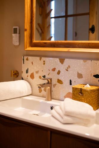 a bathroom with a sink and a mirror and towels at La Maison Clémenceau in Salon-de-Provence