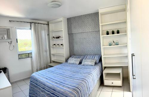 a small bedroom with a bed and shelves at Natal Verano Ponta Negra in Natal