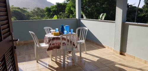 un tavolo su un balcone con tavolo e sedie di Casa Mar e Montanha 1, Vista para o Mar a Trindade