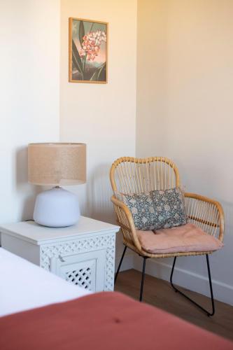 a bedroom with a chair and a table with a lamp at La Maison Clémenceau in Salon-de-Provence