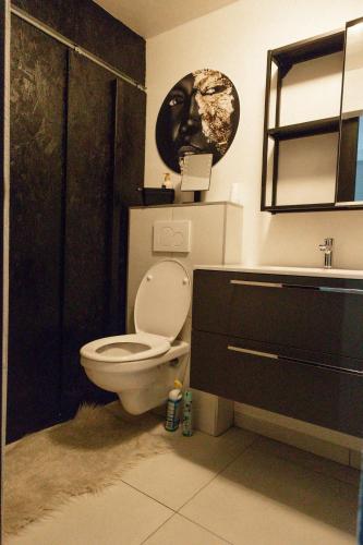 a bathroom with a toilet and a sink at Alivio - Thuiskomen bij jezelf op vakantie in Lummen