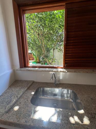 a sink in a kitchen with a window at Flor de Limão Hotel Boutique in Coroa Vermelha